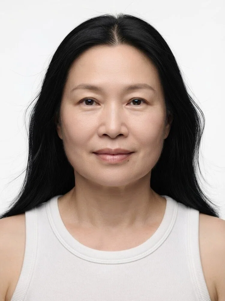 Middle-aged female fashion model with long straight black hair, close-up.
