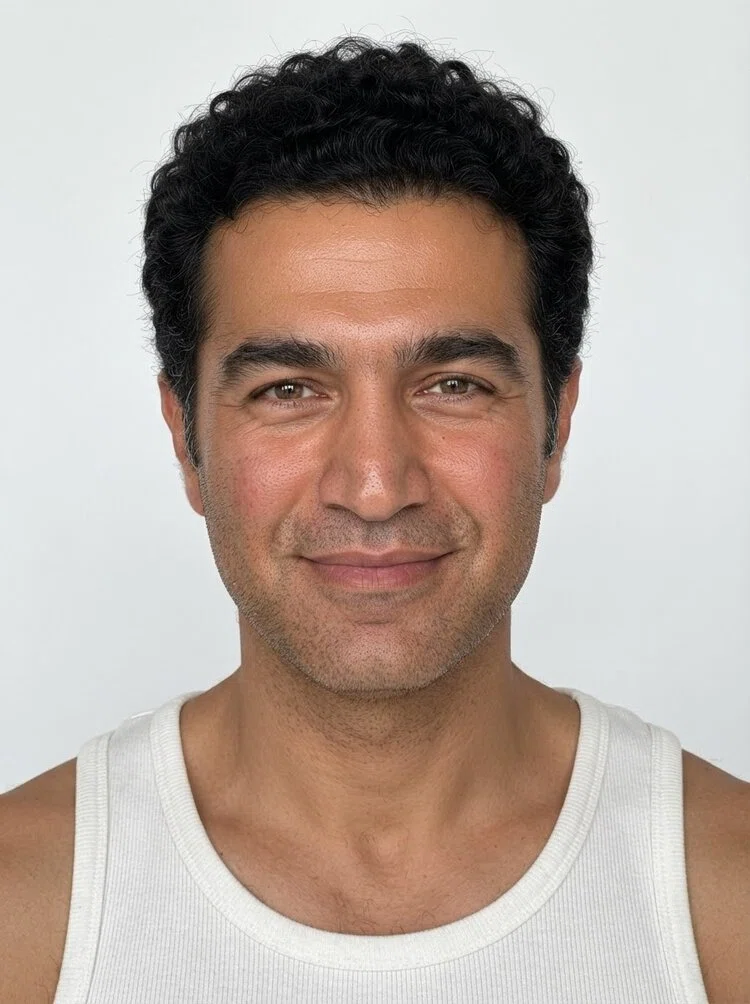 Middle-aged male fashion model with short curly black hair, close-up.