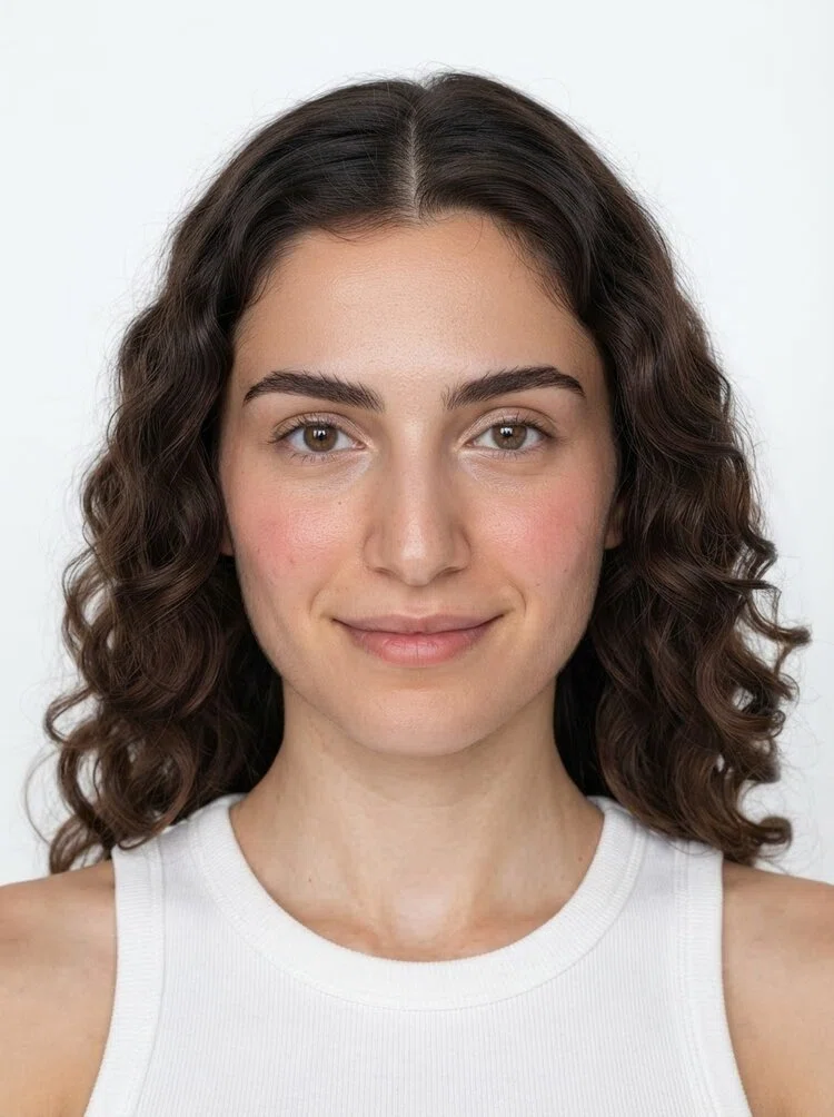 Young female fashion model with shoulder-length wavy dark brown hair, close-up.