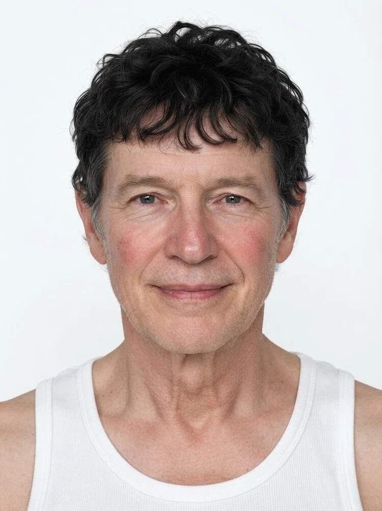 Middle-aged male fashion model with short curly dark hair, close-up.