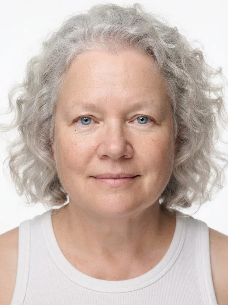 Old female fashion model with short curly silver-grey hair, close-up.